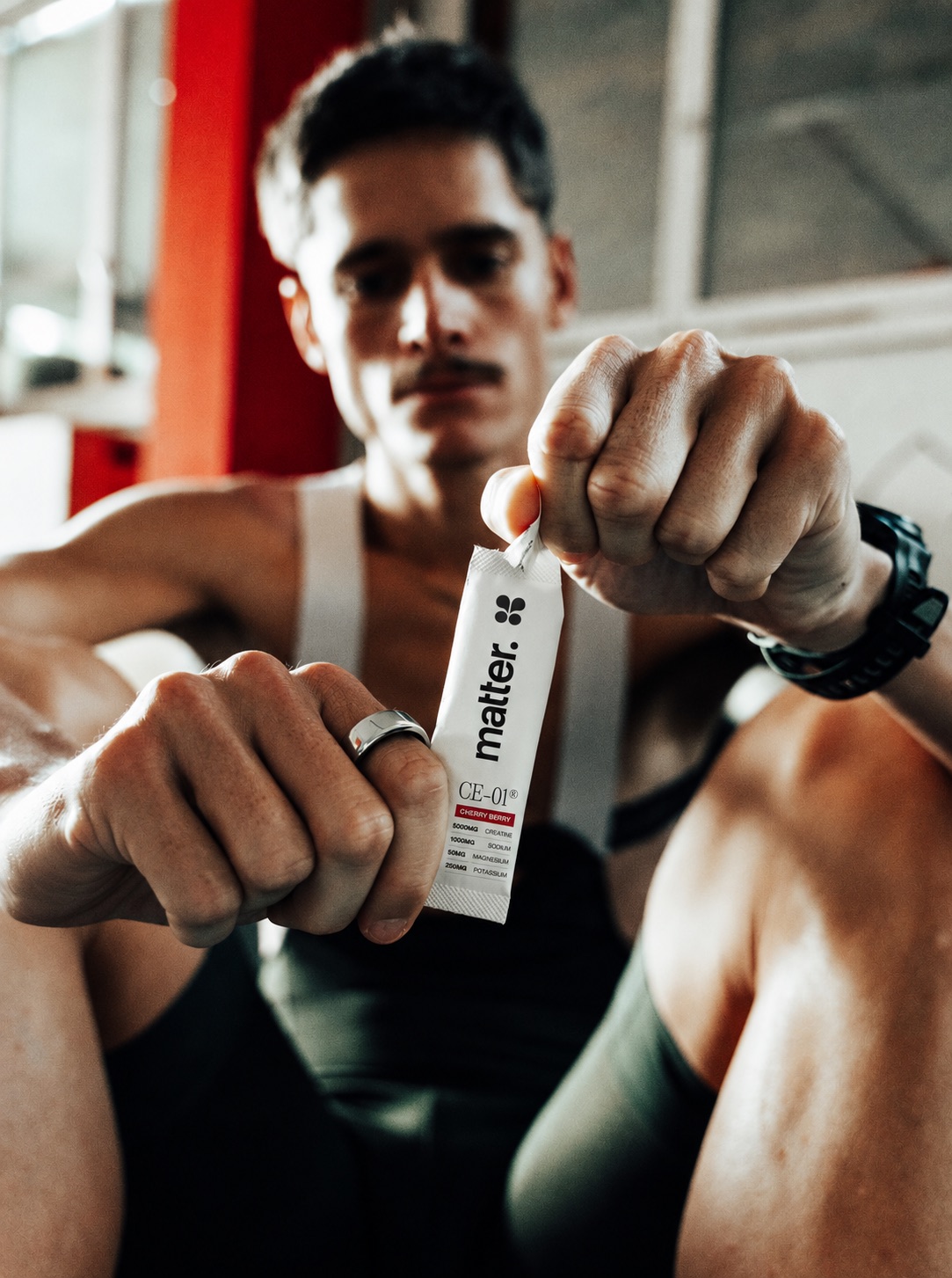 An athlete holding up a CE-01 Cherry Berry sachet