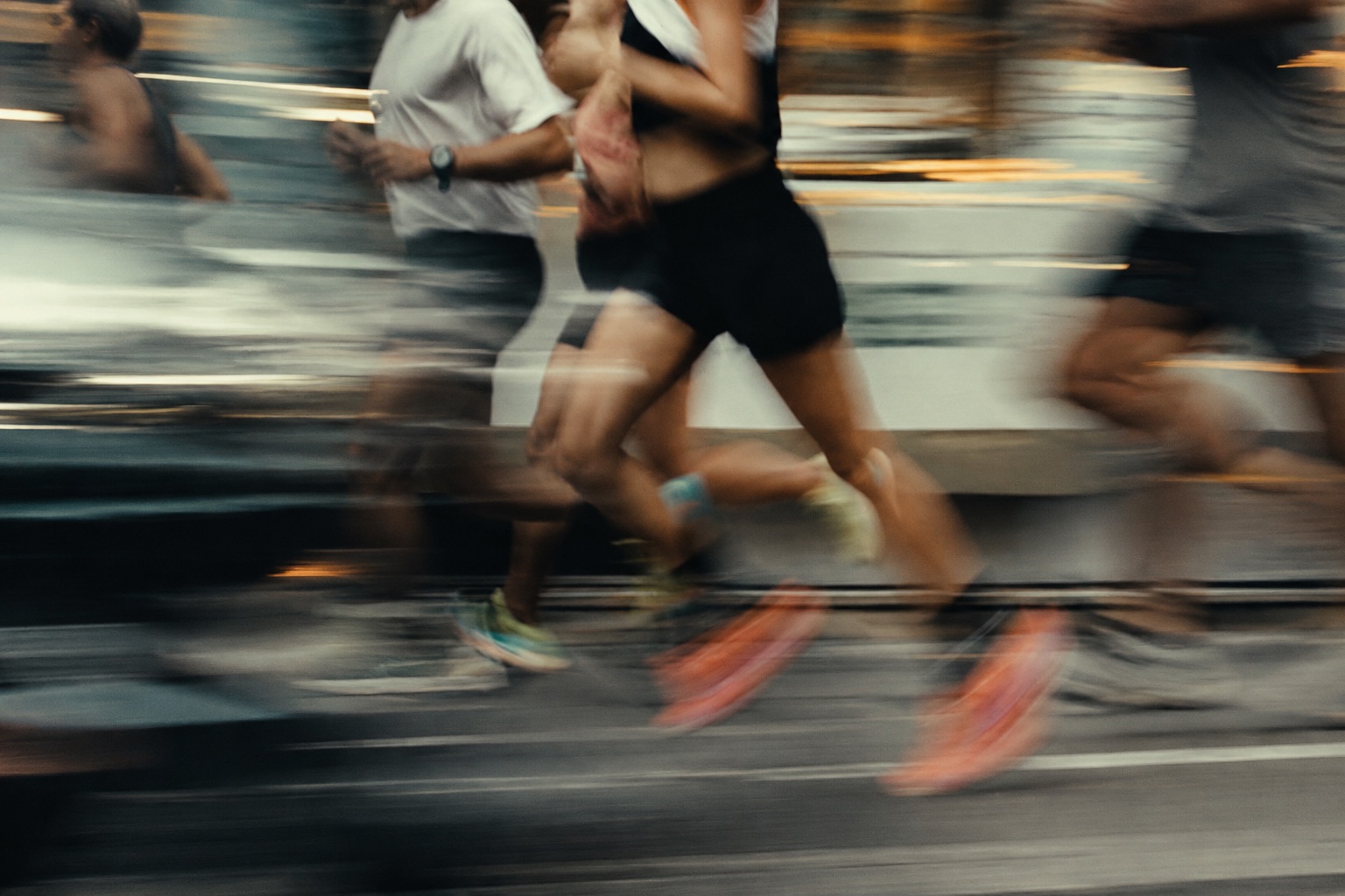 Runners mid-stride on a track, motion-blurred